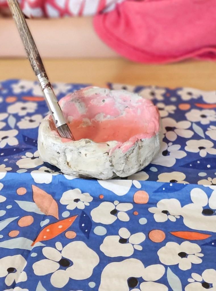 Hand painting a clay bowl