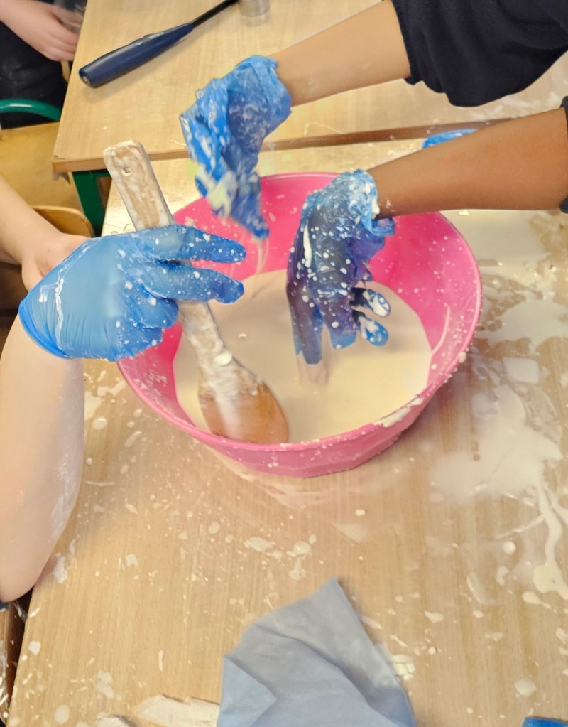3 hands in a bowl making slime